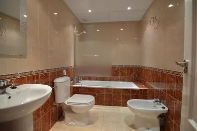 a bathroom with a toilet and a sink and a tub at Piso Aurora in Sanlúcar de Barrameda