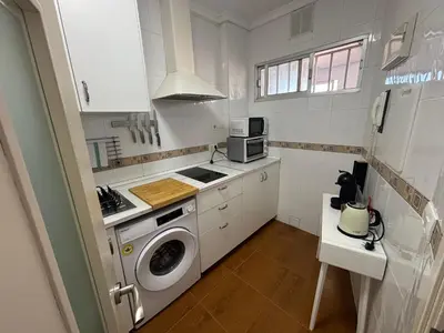 a kitchen with a washer and a washing machine at Apartamento La Mar de Cerca. Terraza vistas Mar. 1ª Linea Playa in Cádiz