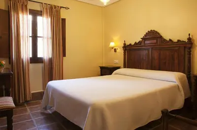 a bedroom with a white bed and a window at Hospedería Santiago in Chiclana de la Frontera