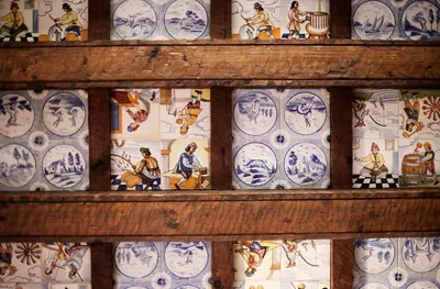 a display of blue and white plates on a wall at Hospedería Santiago in Chiclana de la Frontera