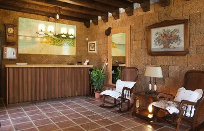 a room with chairs and a counter in a building at Hospedería Santiago in Chiclana de la Frontera