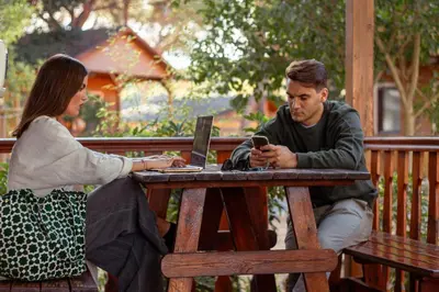 a man and a woman sitting at a table with a laptop at TAIGA Puerto Santa María in El Puerto de Santa María