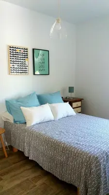 a bedroom with a bed with blue and white pillows at Casa del Mar in Puerto Real
