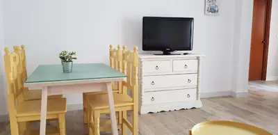 a dining room with a table and a tv on a dresser at Casa del Mar in Puerto Real