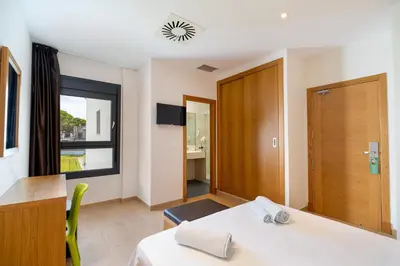 a room with a table and a window and a desk at Complejo Al Sur - by Grupo Tribu in Chiclana de la Frontera