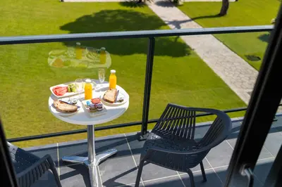 a table with food and two chairs on a balcony at Complejo Al Sur - by Grupo Tribu in Chiclana de la Frontera