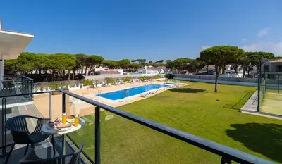 a balcony with a view of a pool and a lawn at Complejo Al Sur - by Grupo Tribu in Chiclana de la Frontera