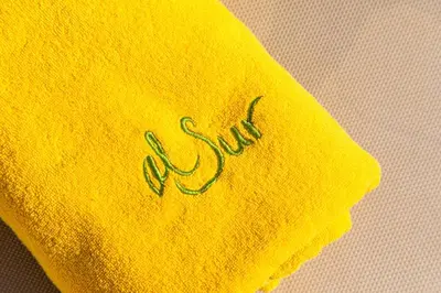 a yellow towel with the word sushi written on it at Complejo Al Sur - by Grupo Tribu in Chiclana de la Frontera