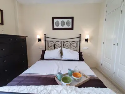 a bedroom with a bed with a tray with bowls on it at ÁTICO TERRAZA 65m. Playa, piscina, A/C, Wifi in Sanlúcar de Barrameda