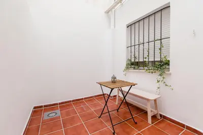 a small table and a bench in a room at Apartamento El Patio de Canovas in Cádiz