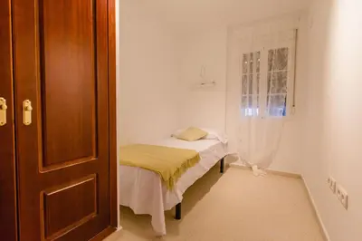 a small room with a small bed and a window at Apartamento El Patio de Canovas in Cádiz
