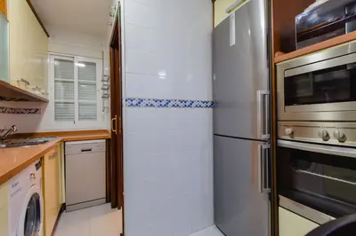 a kitchen with a refrigerator and a microwave at Apartamento El Patio de Canovas in Cádiz