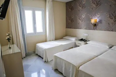 a hotel room with two beds and a window at Chaikana in El Puerto de Santa María