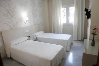 a hotel room with two beds and a window at Chaikana in El Puerto de Santa María