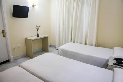 a hotel room with two beds and a tv at Chaikana in El Puerto de Santa María