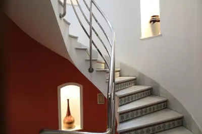 a hallway with stairs with a vase in the middle at Chaikana in El Puerto de Santa María