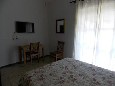a bedroom with a bed and a table and a television at Pensión La Palma in El Puerto de Santa María