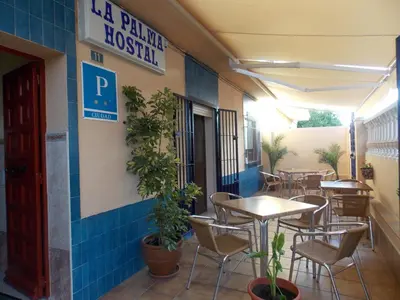 a restaurant with tables and chairs in a building at Pensión La Palma in El Puerto de Santa María