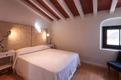 a bedroom with a white bed and a window at Palacio Torneria in Jerez de la Frontera