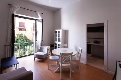 a living room with a table and chairs and a window at Palacio Torneria in Jerez de la Frontera