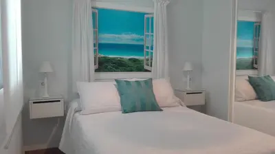 a white bedroom with a bed and a window at Casa Blanca in Rota