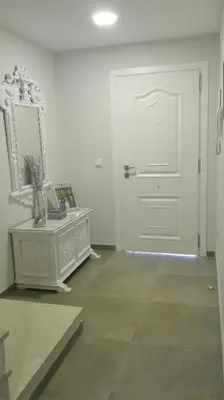 a white room with a door and a mirror at Casa Blanca in Rota