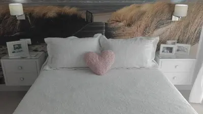 a bed with white pillows with two hearts on it at Casa Blanca in Rota