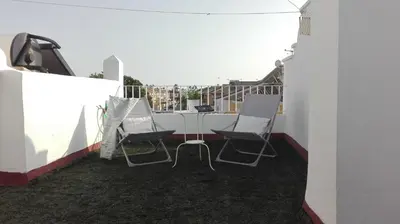 a patio with two chairs and a table on a balcony at Casa Blanca in Rota