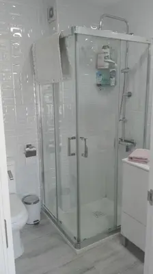 a bathroom with a glass shower with a toilet at Casa Blanca in Rota