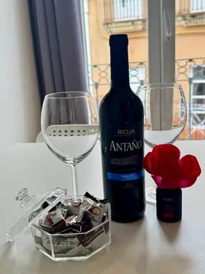 a bottle of wine and two glasses and a box of chocolates at Alcazar Suites in Jerez de la Frontera
