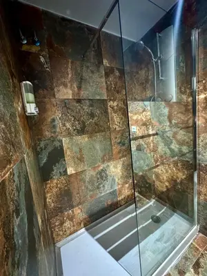 a bathroom with a shower with a glass door at Alcazar Suites in Jerez de la Frontera