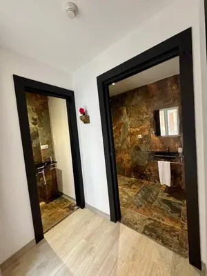 a bathroom with two mirrors and a stone wall at Alcazar Suites in Jerez de la Frontera