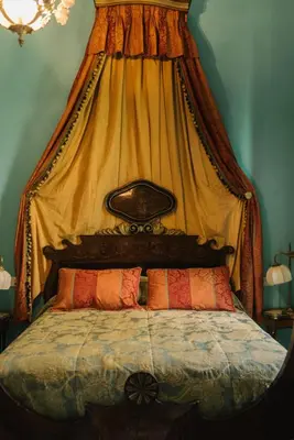 a bed with a canopy with two pillows on it at Palacio del Virrey Laserna in Jerez de la Frontera