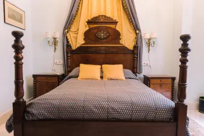 a bedroom with a wooden bed with two pillows at Palacio del Virrey Laserna in Jerez de la Frontera