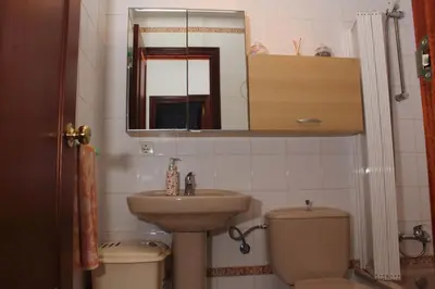 a bathroom with a sink and a toilet and a mirror at Apartamento Tres Carretas Puerto Real in Puerto Real