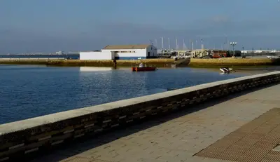 a body of water with a building and boats in it at Apartamento Tres Carretas Puerto Real in Puerto Real