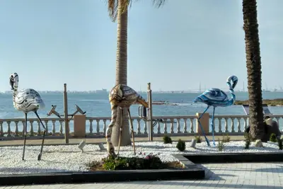 a statue of birds on the beach near the ocean at Apartamento Tres Carretas Puerto Real in Puerto Real