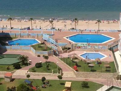 an aerial view of two swimming pools next to a beach at Piso frente la playa de Valdelagrana in El Puerto de Santa María