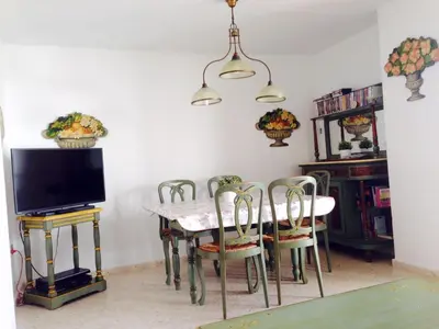 a dining room with a table and chairs and a tv at Piso frente la playa de Valdelagrana in El Puerto de Santa María