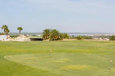 a view of a golf course with a green at Bonito apartamento en campo de golf con piscina in Sanlúcar de Barrameda