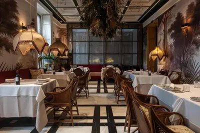 a restaurant with white tables and chairs and a large window at Hotel Casa Palacio María Luisa in Jerez de la Frontera