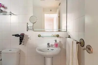a bathroom with a sink and a toilet and a mirror at Modern design apartament in Conil! in Conil de la Frontera