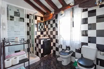 a bathroom with a black and white tiled wall at Apartamentos Jerez in Jerez de la Frontera