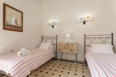 a bedroom with two beds and a dresser with a drawer at Apartamentos Jerez in Jerez de la Frontera