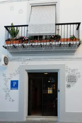 a building with a balcony with flowers on it at Casa de Huéspedes Santa Maria in El Puerto de Santa María