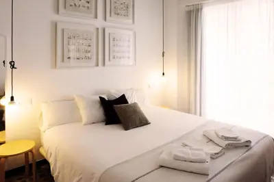 a bedroom with a large white bed with towels on it at Casa de Huéspedes Santa Maria in El Puerto de Santa María