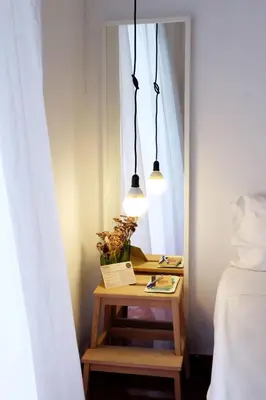 a room with a table with a mirror and two lights at Casa de Huéspedes Santa Maria in El Puerto de Santa María