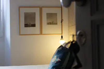 a bed with a lamp and a pillow on it at Casa de Huéspedes Santa Maria in El Puerto de Santa María