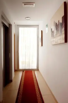 a hallway with a large window and a red rug at Hostal San Marcos in San Fernando