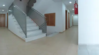 a staircase in a building with a glass railing at Hostal San Marcos in San Fernando